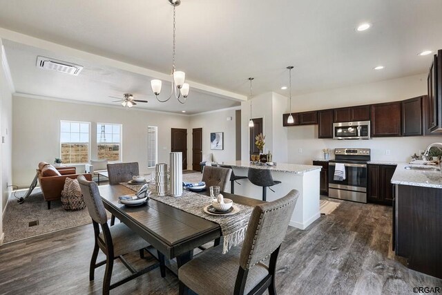 dining space with crown molding, sink, ceiling fan with notable chandelier, and dark hardwood / wood-style floors