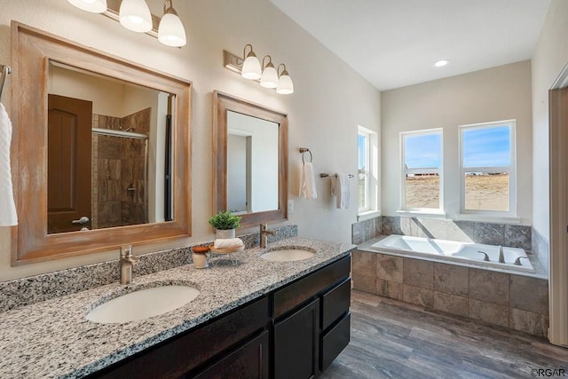 bathroom featuring vanity, wood-type flooring, and shower with separate bathtub