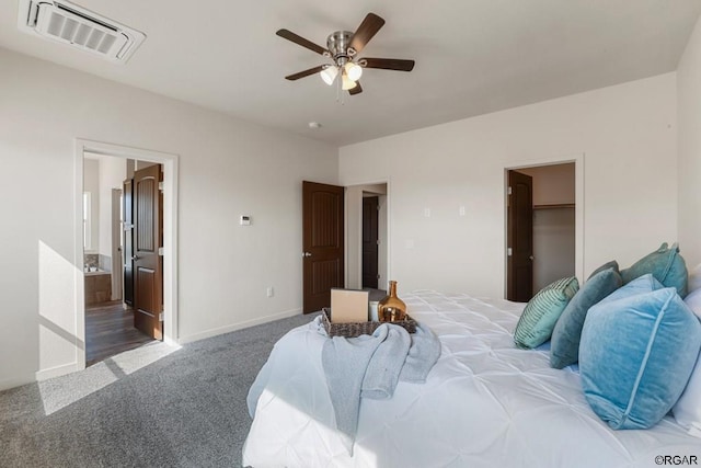 bedroom featuring a spacious closet, ceiling fan, dark carpet, ensuite bath, and a closet