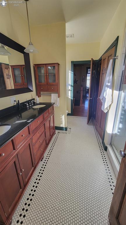120 E Main St, Florence, CO 81226 - full bathroom with visible vents, a stall shower, double vanity, and a sink