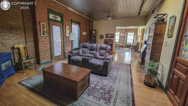 120 E Main St, Florence, CO 81226 - living area with an ornate ceiling, brick wall, a ceiling fan, and wood-type flooring