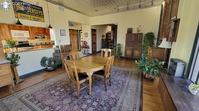120 E Main St, Florence, CO 81226 - dining room featuring track lighting, an ornate ceiling, wood finished floors, and visible vents