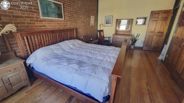 120 E Main St, Florence, CO 81226 - bedroom featuring brick wall and wood-type flooring