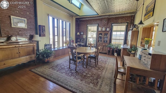 120 E Main St, Florence, CO 81226 - dining space with an ornate ceiling, a healthy amount of sunlight, brick wall, and hardwood / wood-style floors