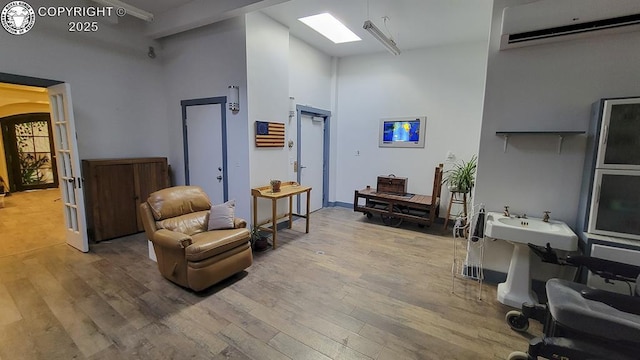 120 E Main St, Florence, CO 81226 - sitting room with a wall mounted air conditioner, a high ceiling, and wood finished floors