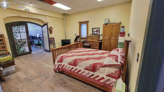 120 E Main St, Florence, CO 81226 - bedroom featuring wood finished floors, access to exterior, arched walkways, and a paneled ceiling