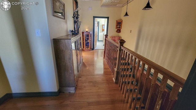 120 E Main St, Florence, CO 81226 - hall with hardwood / wood-style floors, baseboards, and an upstairs landing