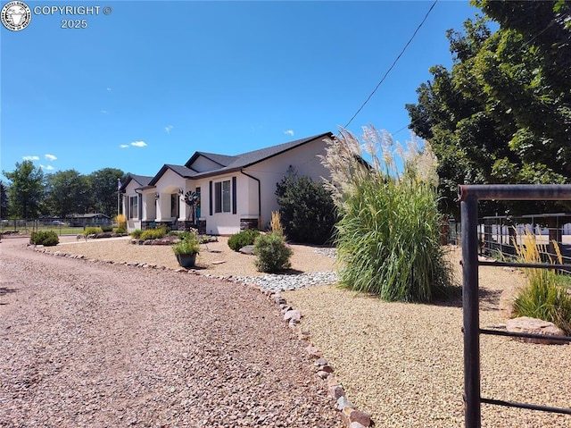 view of front of home featuring fence and stucco siding