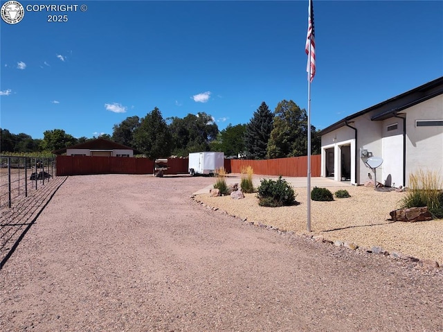 view of yard with driveway and fence