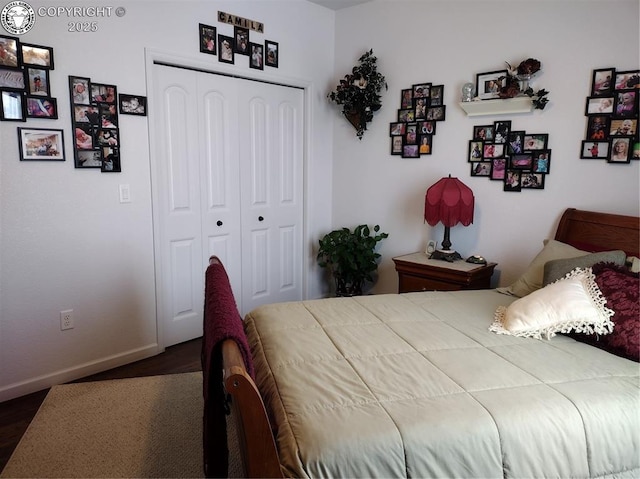 bedroom featuring dark wood-type flooring, a closet, and baseboards