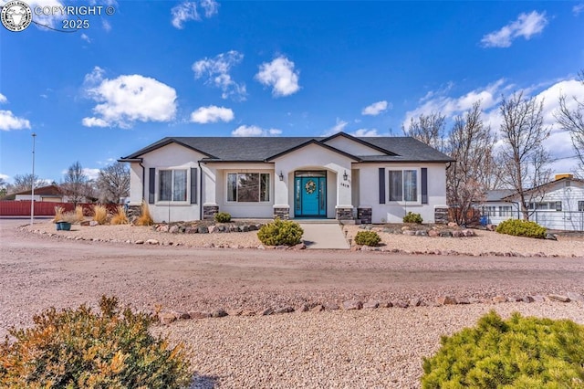 view of front of house with fence and stucco siding