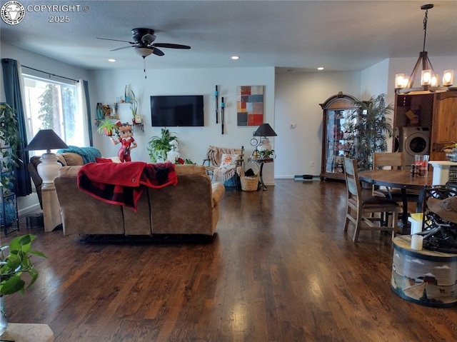 living area with recessed lighting, wood finished floors, washer / dryer, baseboards, and ceiling fan with notable chandelier