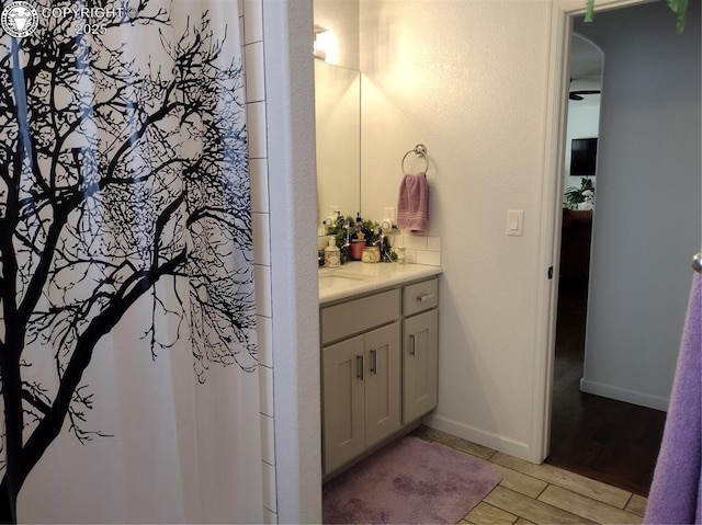 full bathroom featuring a shower with curtain, vanity, baseboards, and wood finished floors