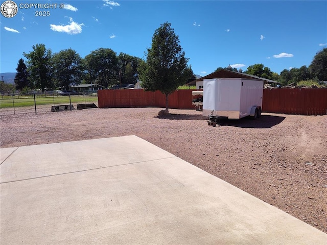 view of yard with a patio, a storage unit, an outdoor structure, and fence