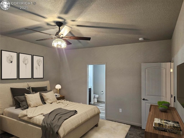 bedroom featuring ceiling fan, light colored carpet, a textured ceiling, and ensuite bathroom