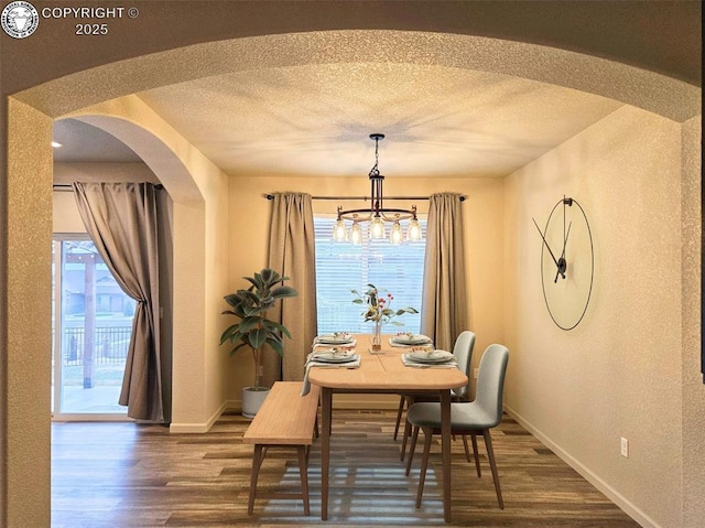 dining room with dark wood-type flooring and a textured ceiling