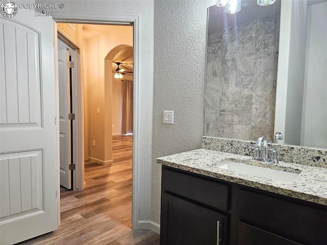 bathroom with ceiling fan, wood-type flooring, and vanity