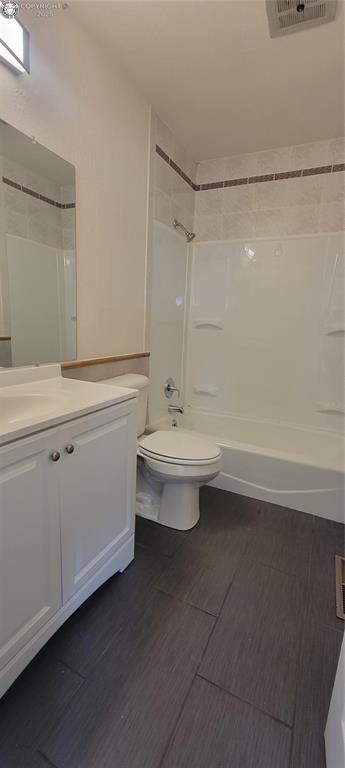 bathroom with washtub / shower combination, wood finished floors, visible vents, toilet, and vanity