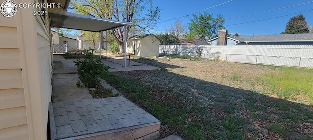 view of yard with an outbuilding, a patio, and a fenced backyard
