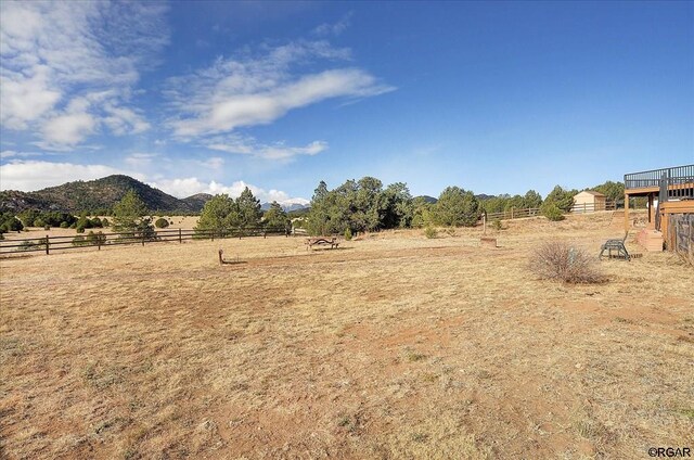 view of yard with a rural view and a mountain view