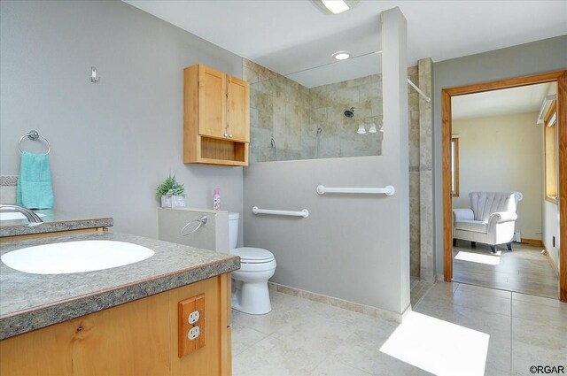 bathroom featuring vanity, toilet, and tiled shower