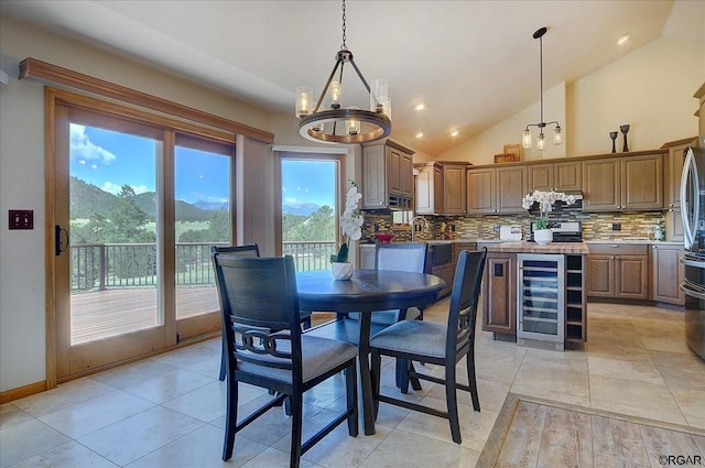 tiled dining room with a notable chandelier, sink, vaulted ceiling, and beverage cooler