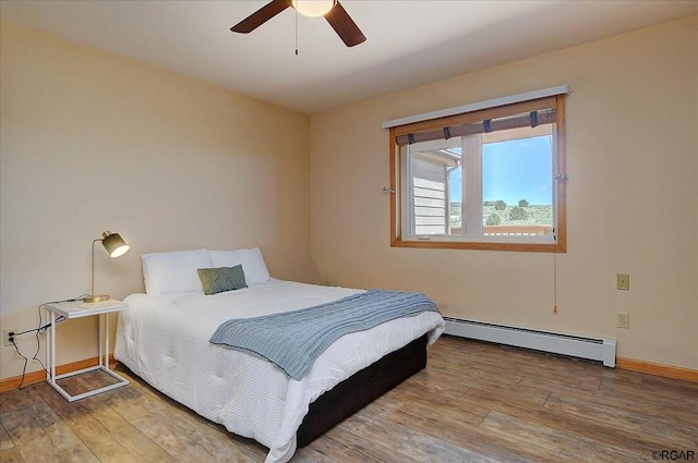 bedroom with baseboard heating, ceiling fan, and hardwood / wood-style flooring