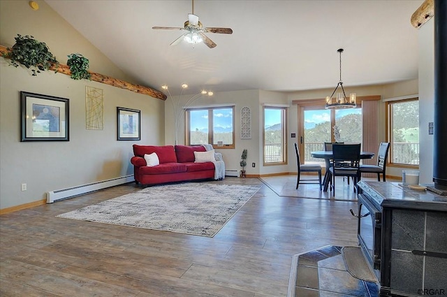 living room featuring baseboard heating, ceiling fan, wood-type flooring, and vaulted ceiling