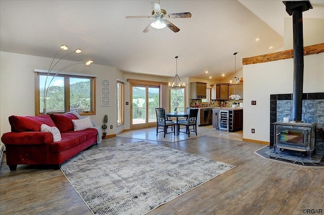 living room featuring ceiling fan, plenty of natural light, light hardwood / wood-style flooring, and a wood stove