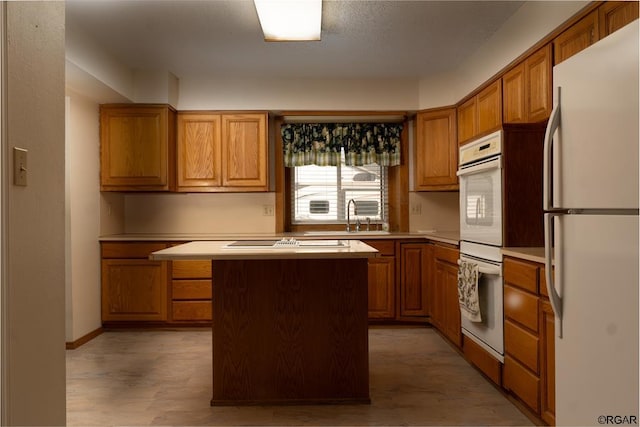 kitchen featuring sink, white appliances, and a center island