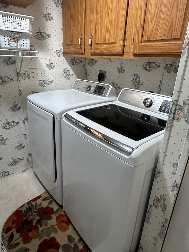 laundry area featuring cabinets and washer and clothes dryer