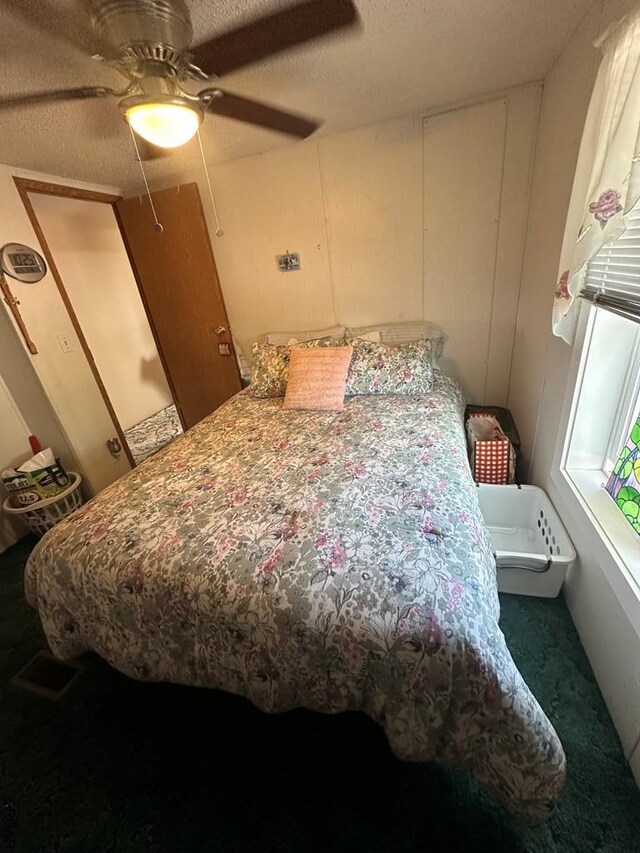 bedroom with a textured ceiling and ceiling fan