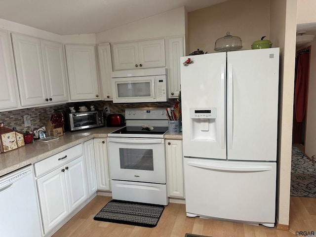 kitchen with backsplash, white appliances, light wood-type flooring, and white cabinets