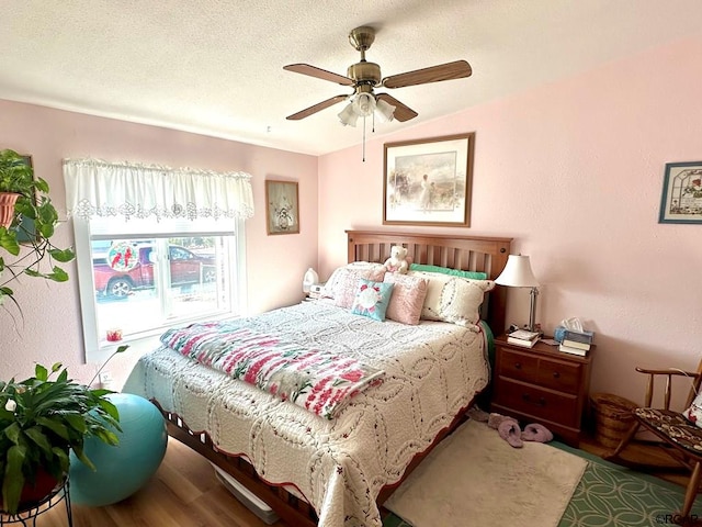 bedroom featuring vaulted ceiling, hardwood / wood-style floors, a textured ceiling, and ceiling fan