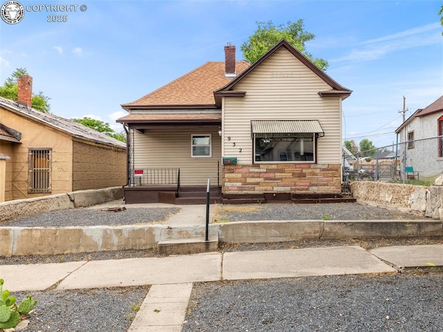 932 Elm St, Pueblo, CO 81004 - view of front of property featuring a chimney, a porch, stone siding, and roof with shingles