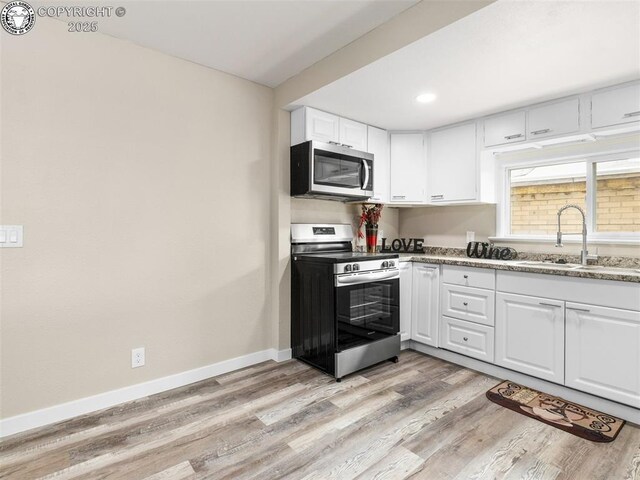 932 Elm St, Pueblo, CO 81004 - kitchen featuring stainless steel appliances, a sink, white cabinets, light wood-style floors, and recessed lighting