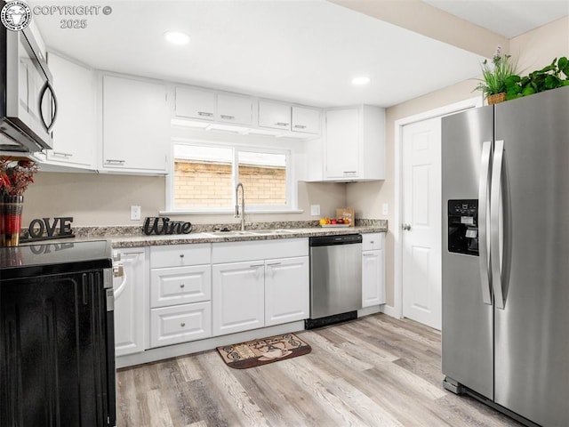 932 Elm St, Pueblo, CO 81004 - kitchen with stainless steel appliances, a sink, white cabinetry, light wood-style flooring, and recessed lighting
