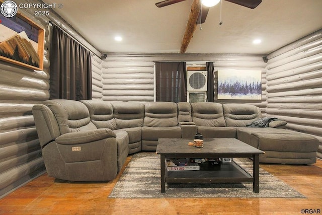 cinema room with ceiling fan, wood-type flooring, and beamed ceiling