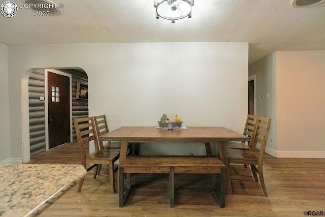 dining area with hardwood / wood-style floors and a textured ceiling