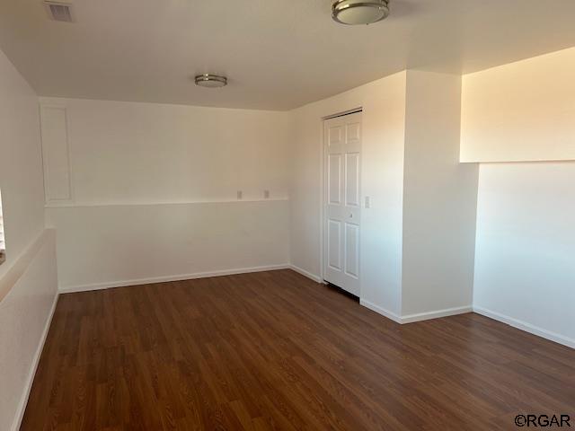 unfurnished room featuring dark wood-type flooring