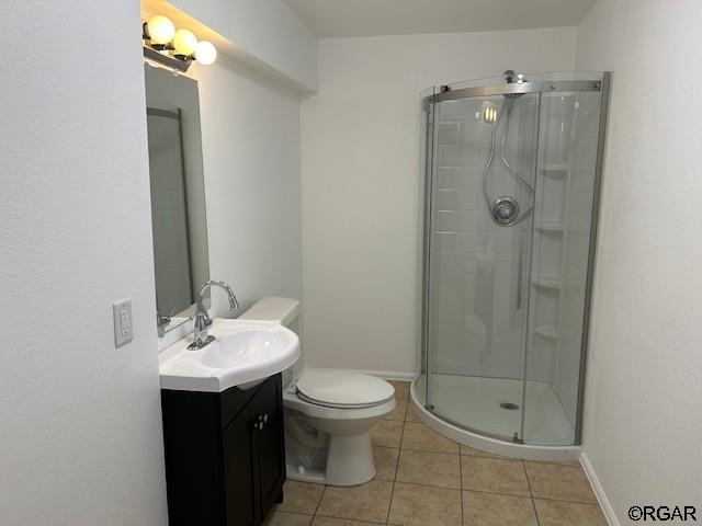 bathroom with walk in shower, vanity, toilet, and tile patterned flooring