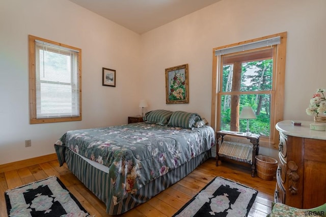 bedroom with multiple windows and light hardwood / wood-style flooring