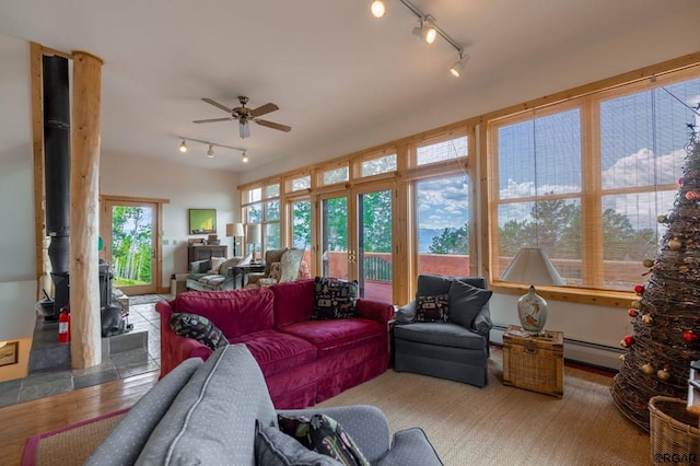 sunroom / solarium featuring ceiling fan and baseboard heating