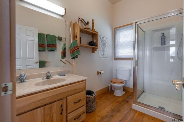 bathroom featuring toilet, hardwood / wood-style floors, vanity, and a shower with shower door