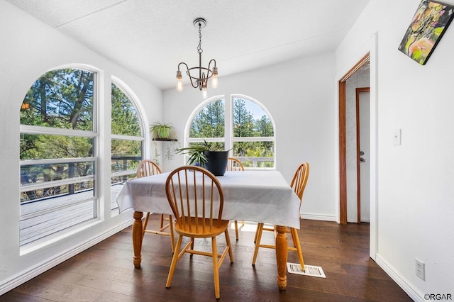 dining area with an inviting chandelier and dark wood-type flooring