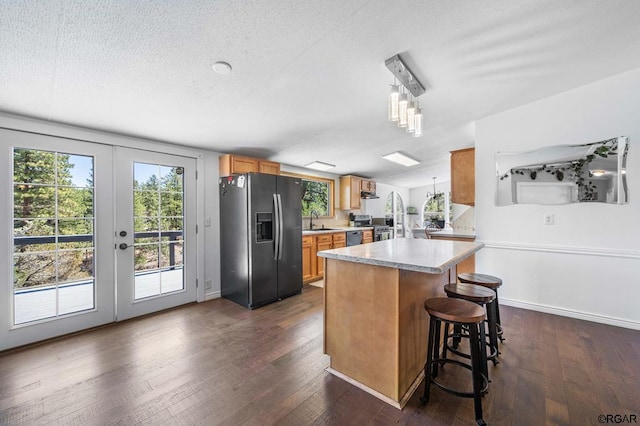 kitchen with french doors, dark wood-type flooring, sink, black refrigerator with ice dispenser, and pendant lighting