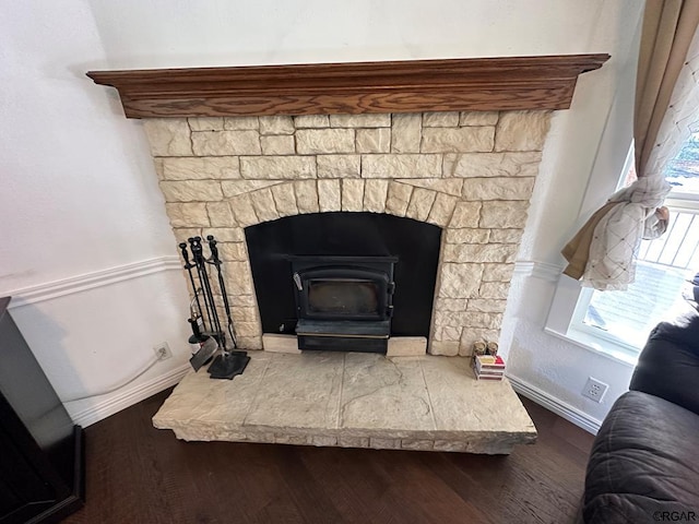 interior details with hardwood / wood-style flooring and a wood stove