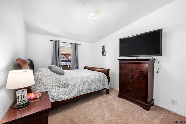 carpeted bedroom with lofted ceiling