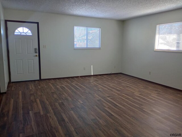 entryway with dark hardwood / wood-style floors and a textured ceiling