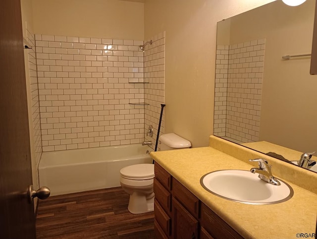 full bathroom featuring hardwood / wood-style flooring, vanity, toilet, and tiled shower / bath combo